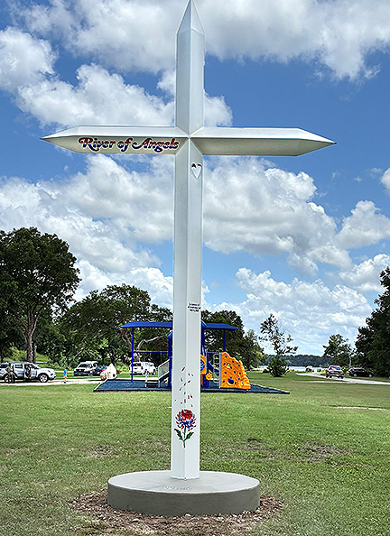 A large white memorial cross stands on the bank of the Guadalupe River in Kerr County, Texas. - Courtesy Photo